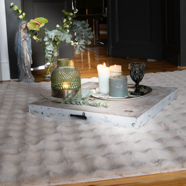 Aspen Teppich hochflor Beige ausgelegt im Raum mit Dekoartikel im Hintergrund Ambiente Aufnahme